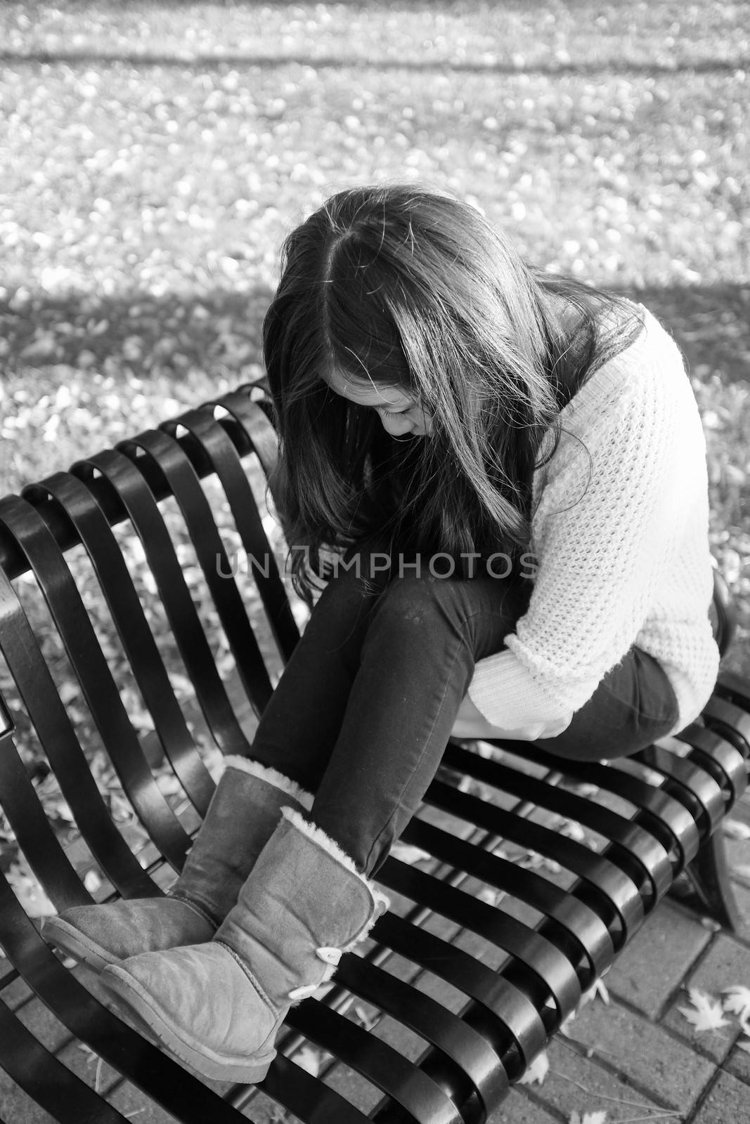 Woman sitting on bench by IVYPHOTOS