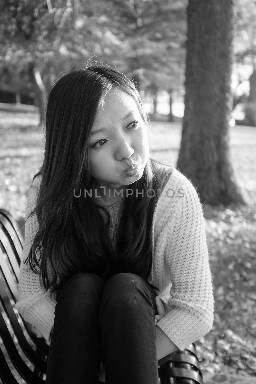 Woman sitting on bench by IVYPHOTOS