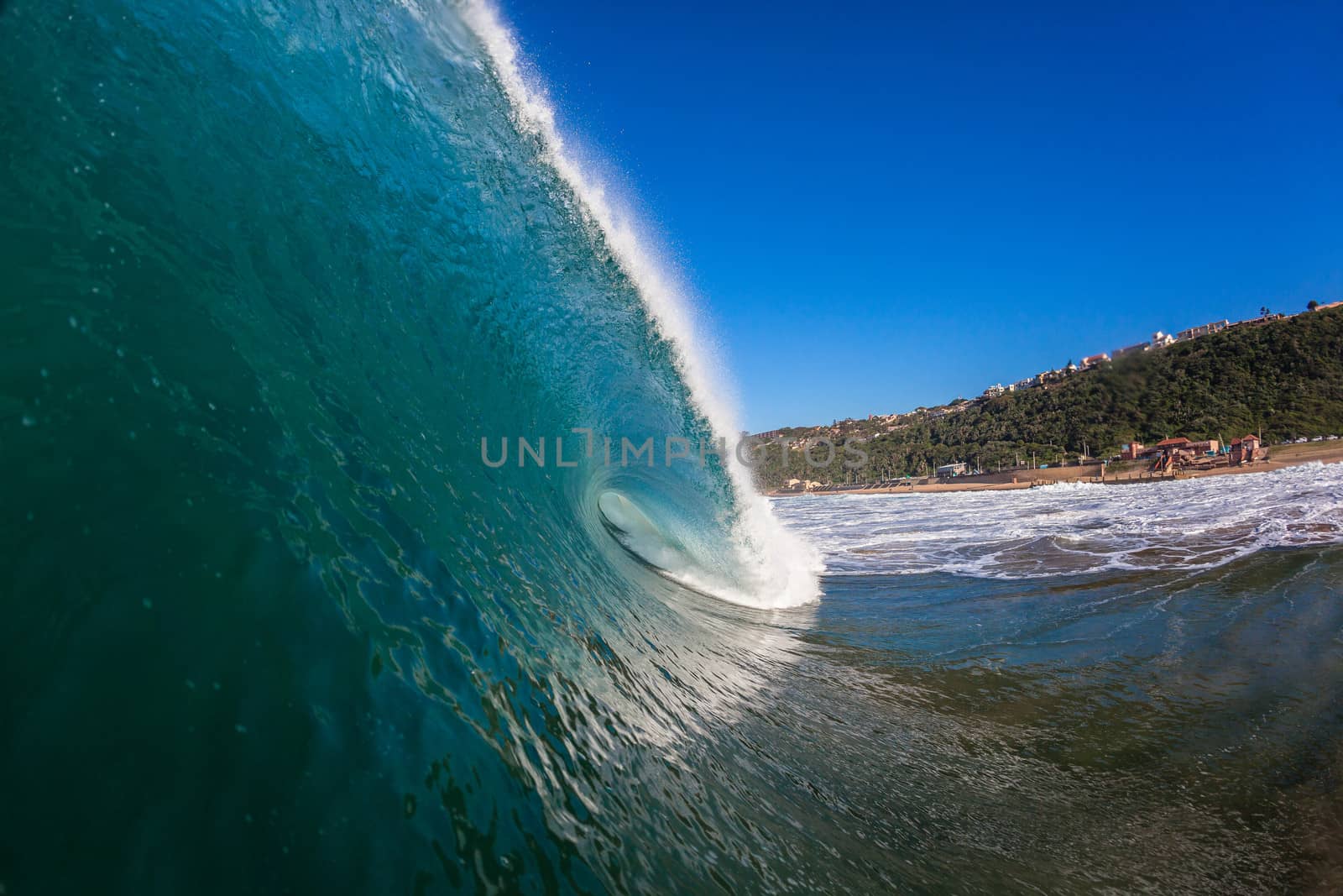 Water angle of large ocean wave crashing breaking towards the beach reefs and sandbars.