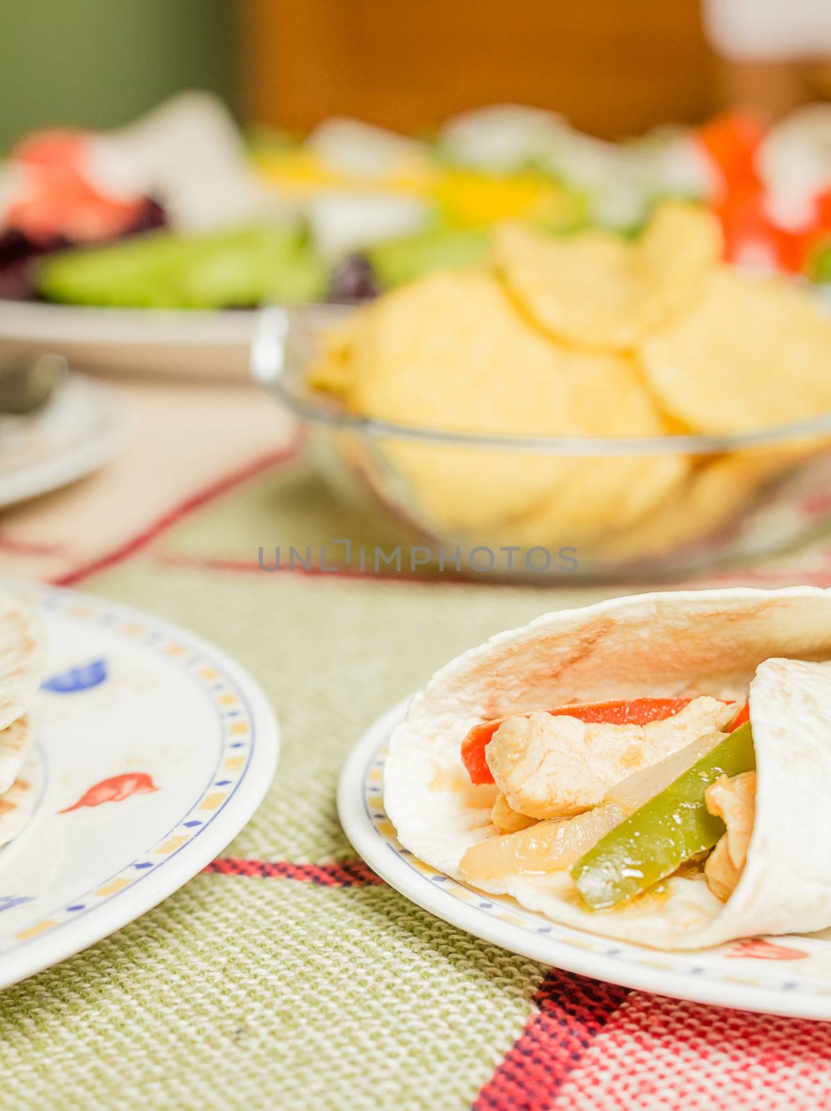 Traditional mexican food in a table, with chicken fajita, fresh salad and bowl of nachos