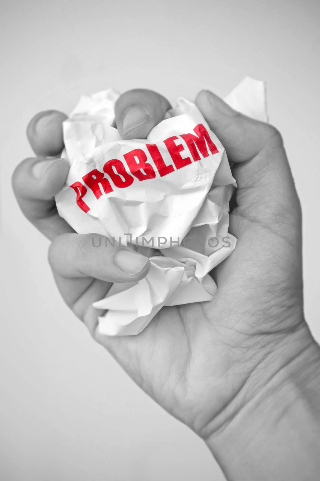 Problem solving concept symbolised with hand squashing a crumpled piece of paper  