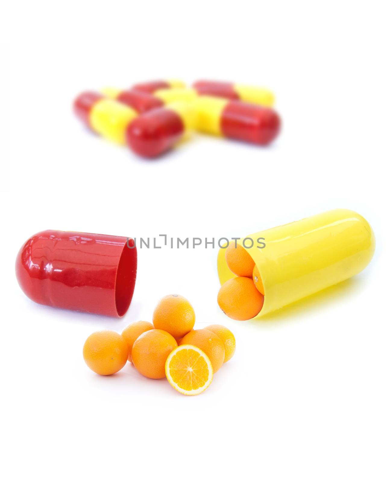 Miniature oranges inside a vitamin pill capsule 