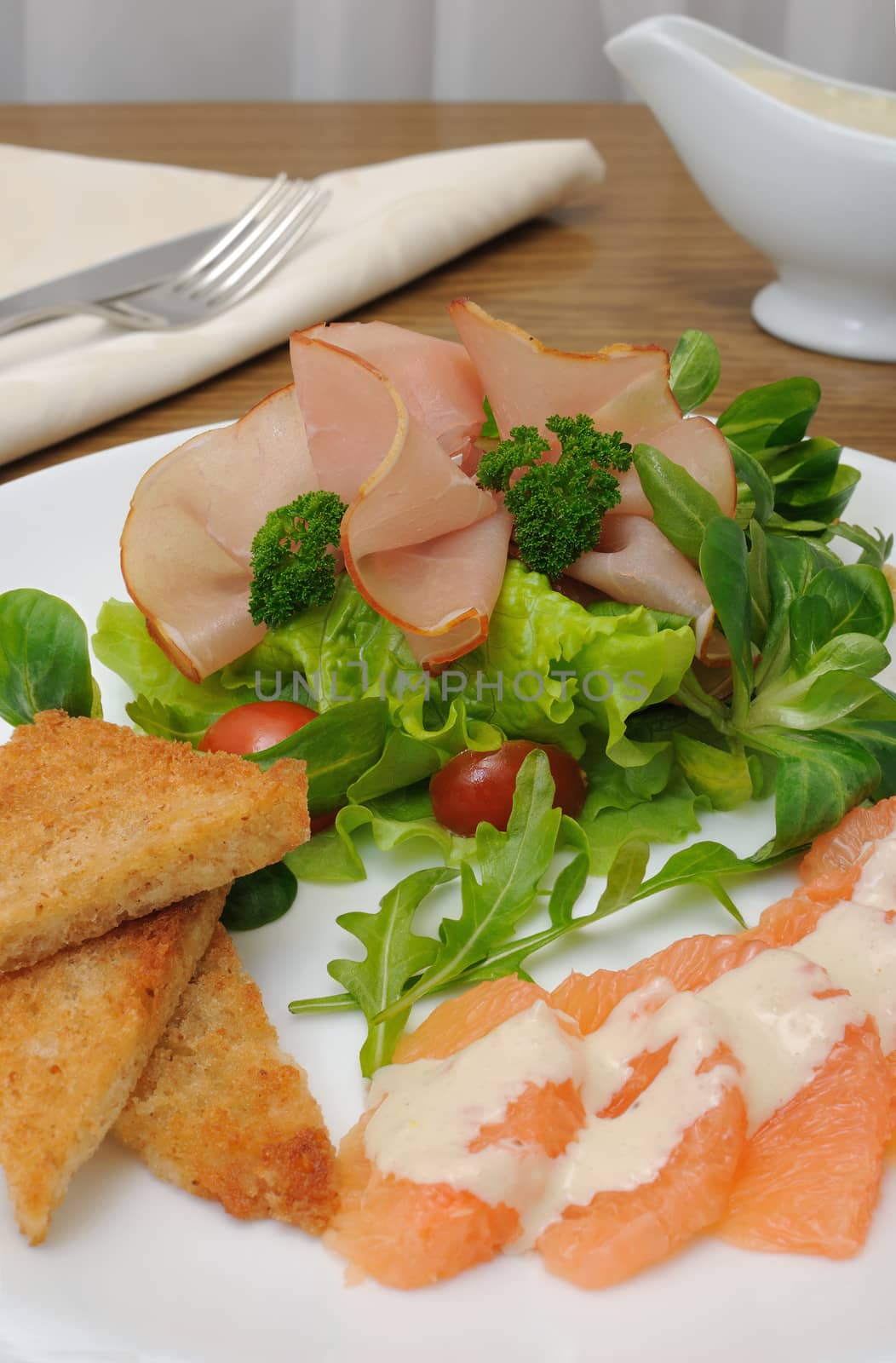 Salad mix with cherry tomatoes and ham with, toast with grapefruit cream sauce