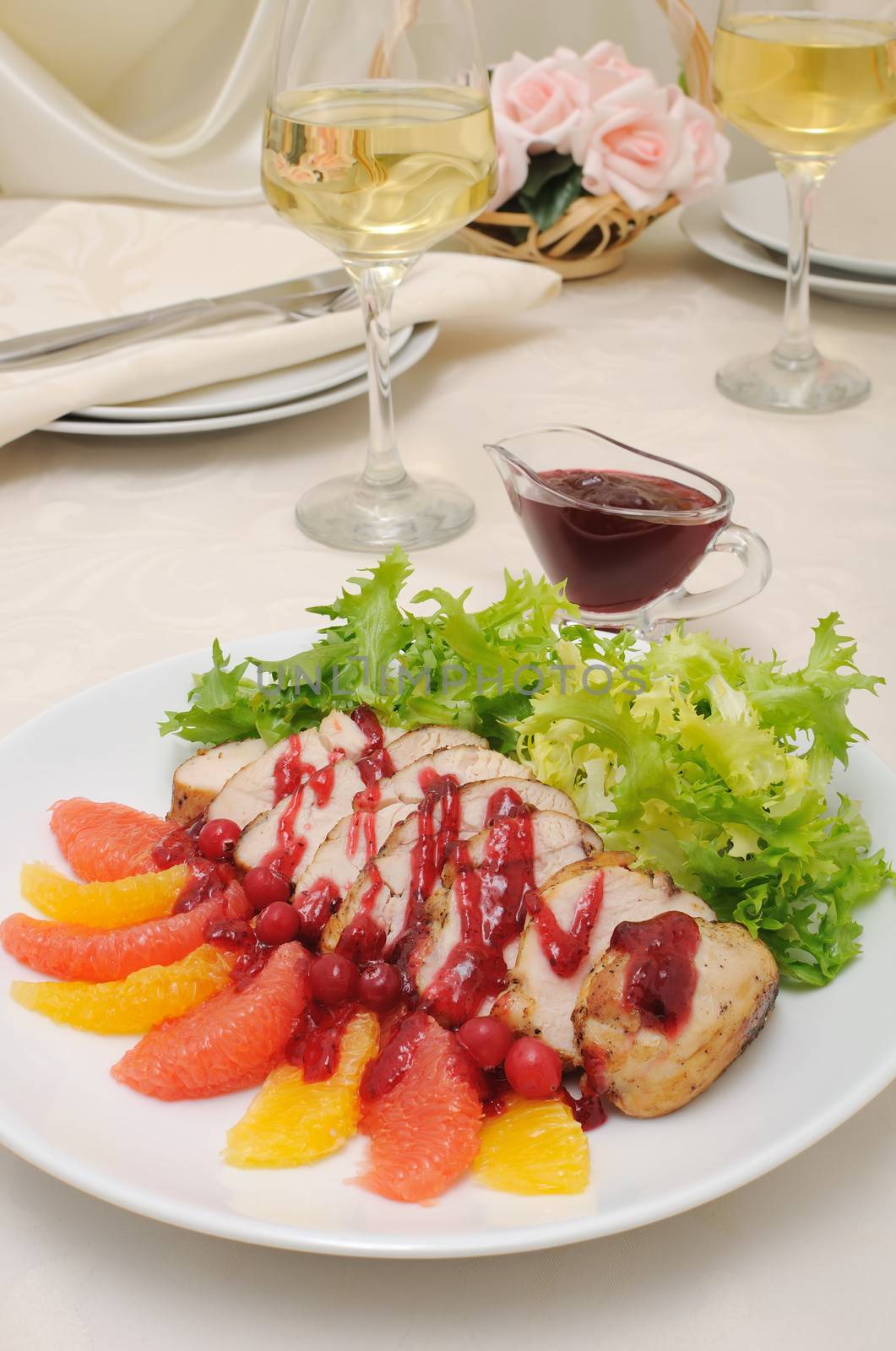 Sliced ​​baked fillet with cranberry sauce in lettuce leaves with orange and grapefruit