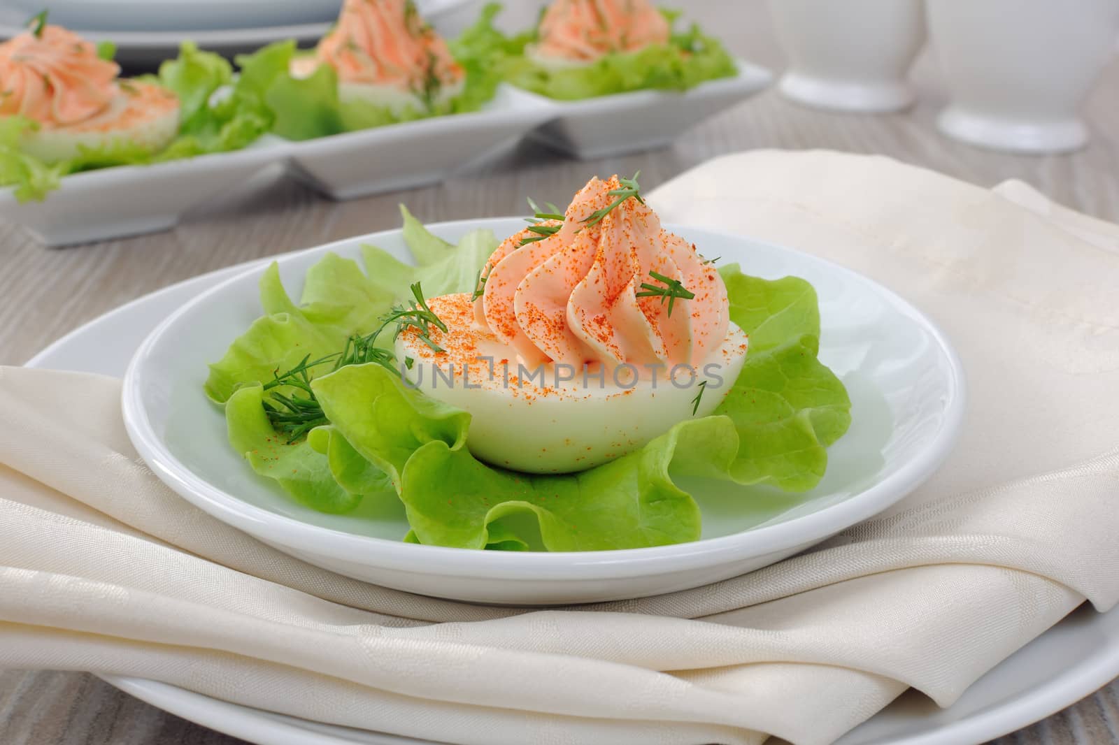 Eggs stuffed with pate salmon with red pepper in lettuce leaves