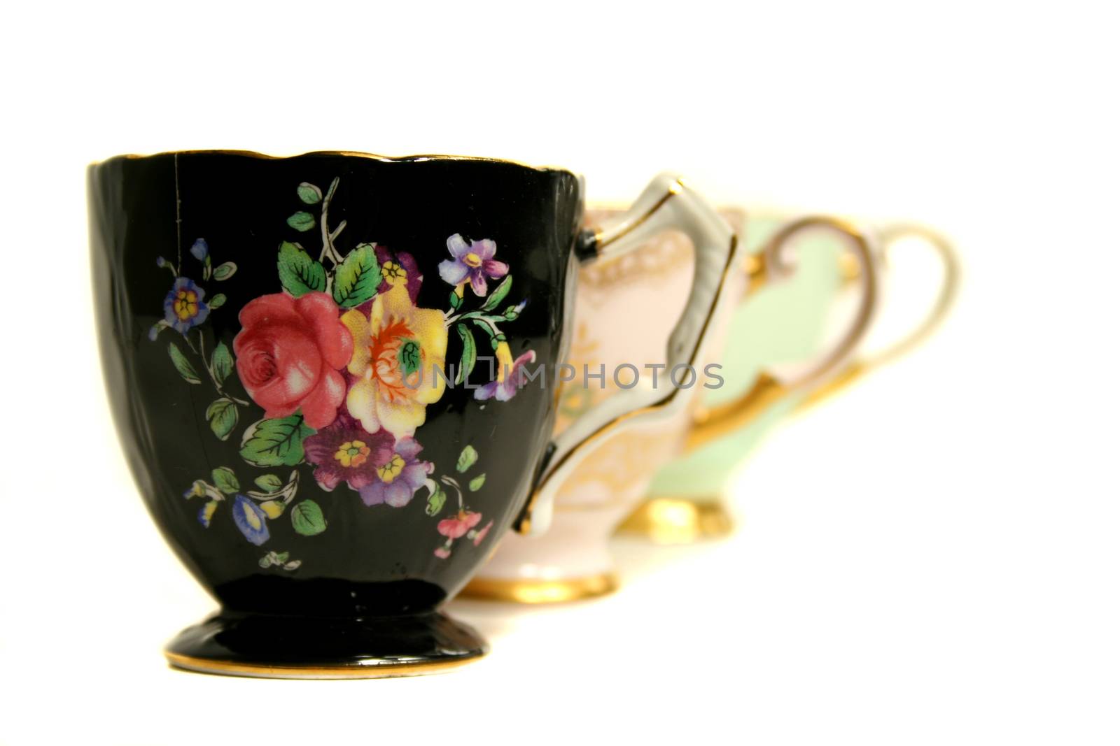 Three different colored antique teacups echoed in a line.