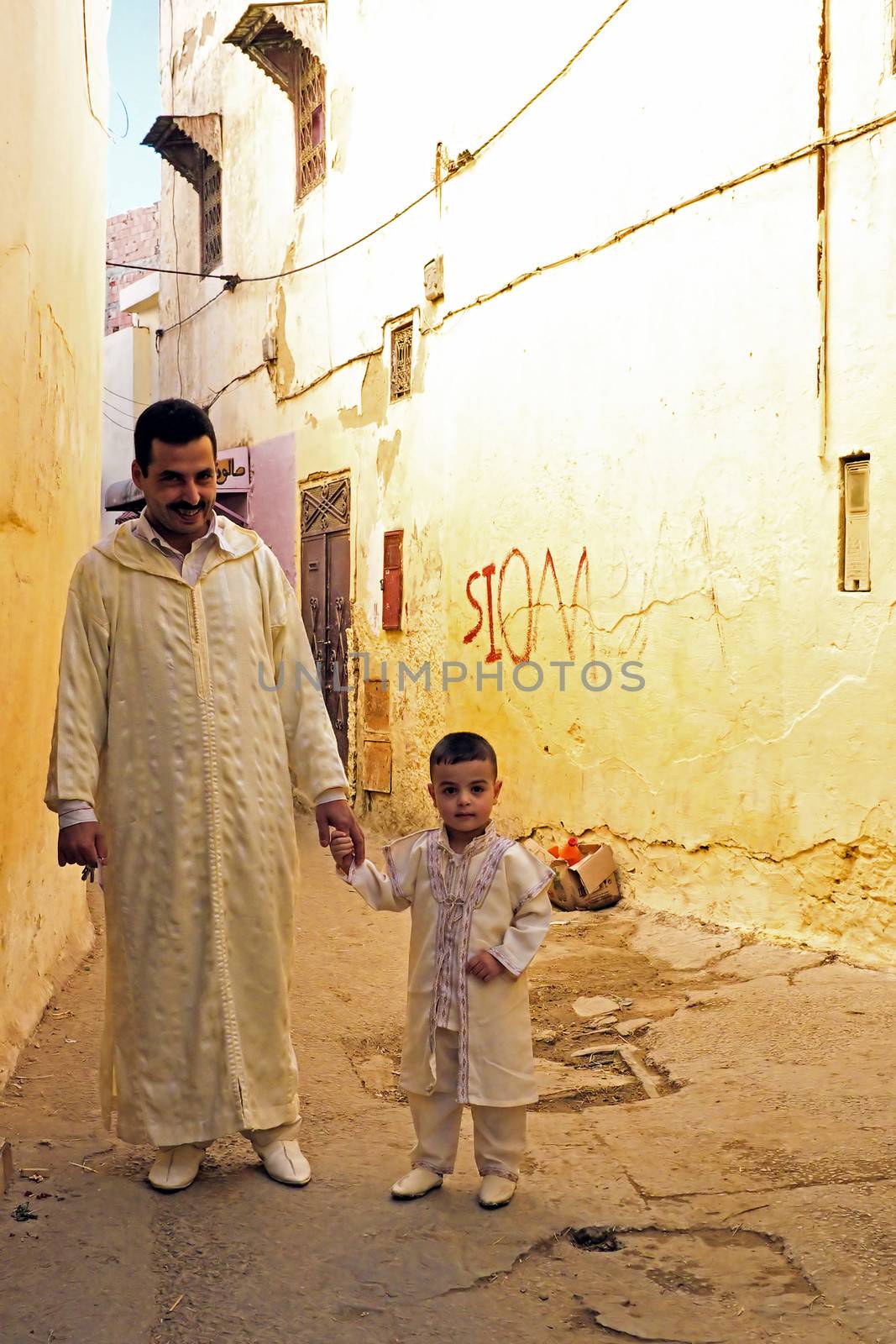 FES, MAROCCO - October 15 2013 : Father and son are dressed up on Eid al-Adha. The festival is celebrated by sacrificing a lamb or other animal and distributing the meat to relatives, friends, and the poor.