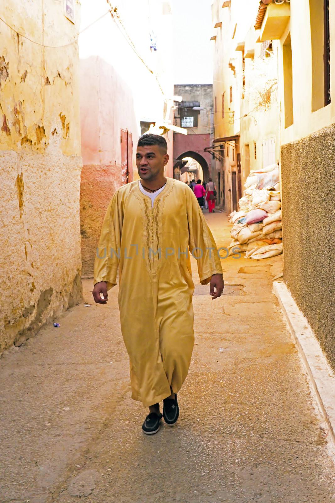 FES, MAROCCO - October 15 2013 : Man walking in the medina on Eid al-Adha. The festival is celebrated by sacrificing a lamb or other animal and distributing the meat to relatives, friends, and the poor.