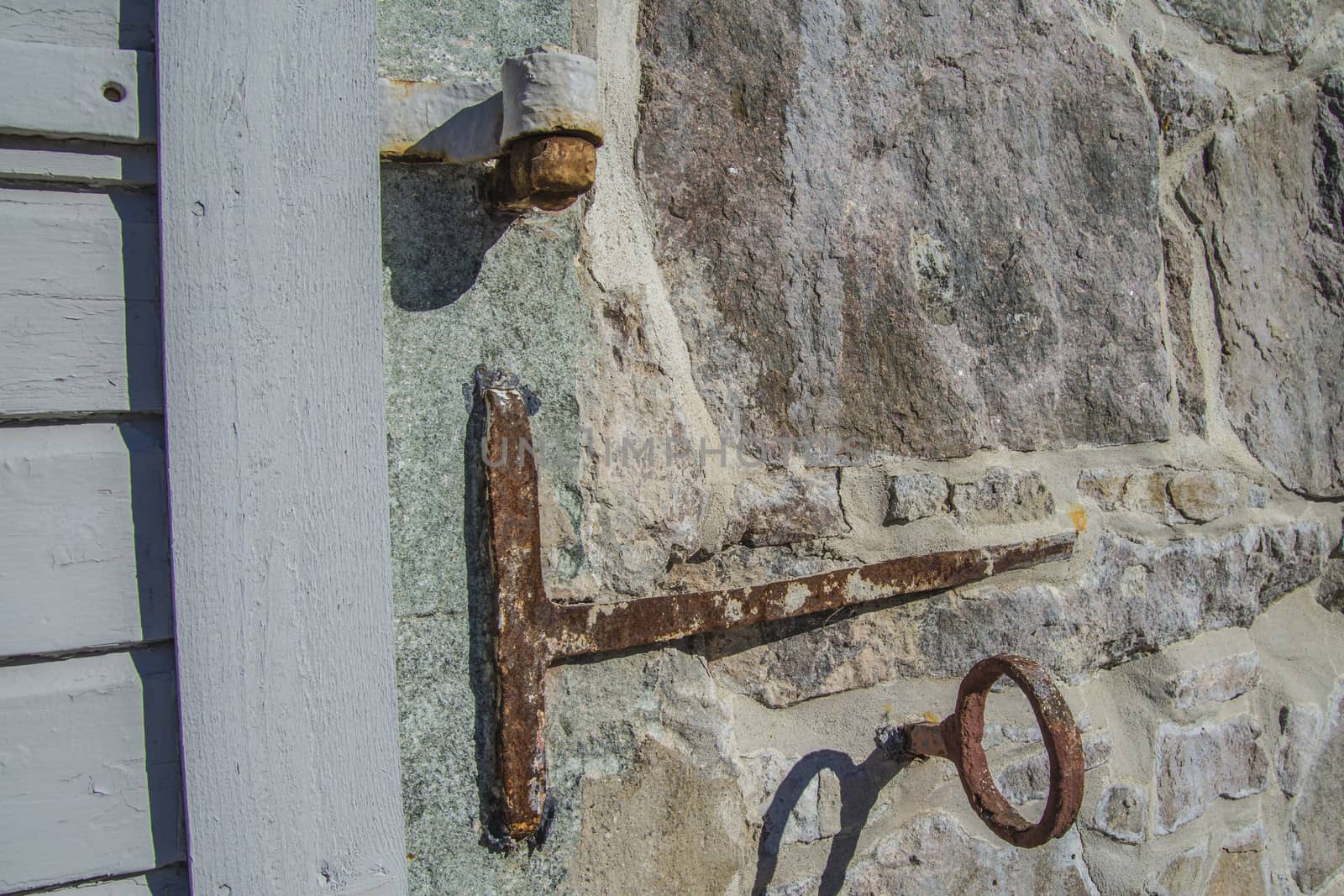 detail of wrought iron hooks fastened to the stone wall on the r by steirus