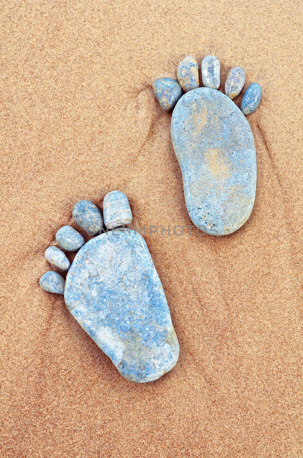 Footsteps of pebbles on the sandy beach