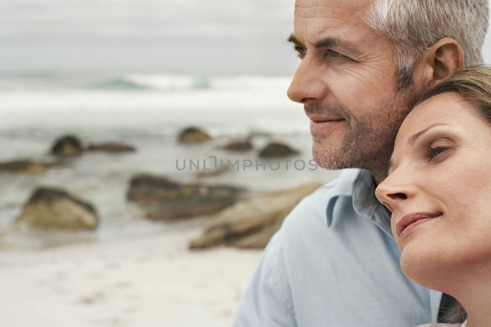 Closeup of romantic couple looking away at beach by moodboard