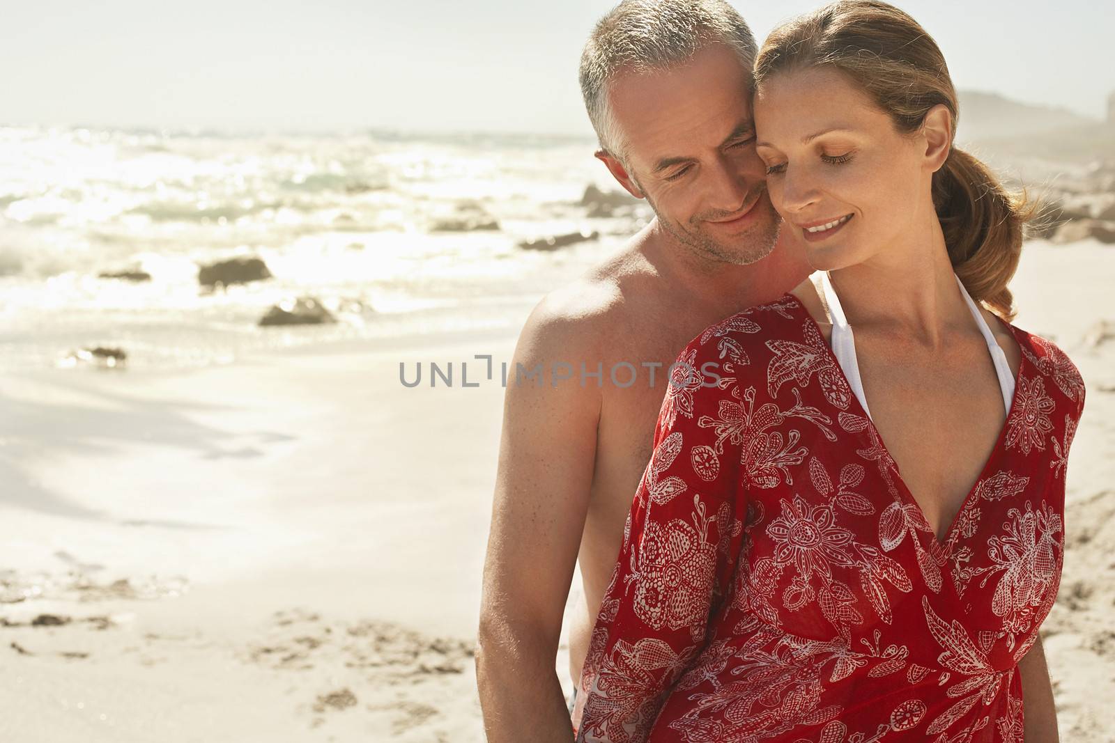 Happy romantic couple standing at beach by moodboard