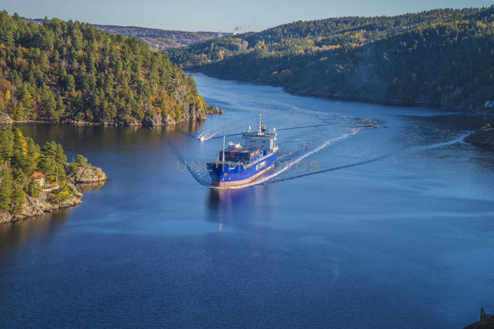 MV Lysbris sailing through Ringdalsfjord from Halden, Norway harbor and out to the open ocean. Vessel's Details: Ship Type: Cargo / container ship, built 1999, Length x Breadth: 129 m X 18 m, Gross Tonnage: 7409, DWT (deadweight tons): 7500 h, Flag: Norway (NO). Photo is shot from Svinesund bridge 18 October 2013.