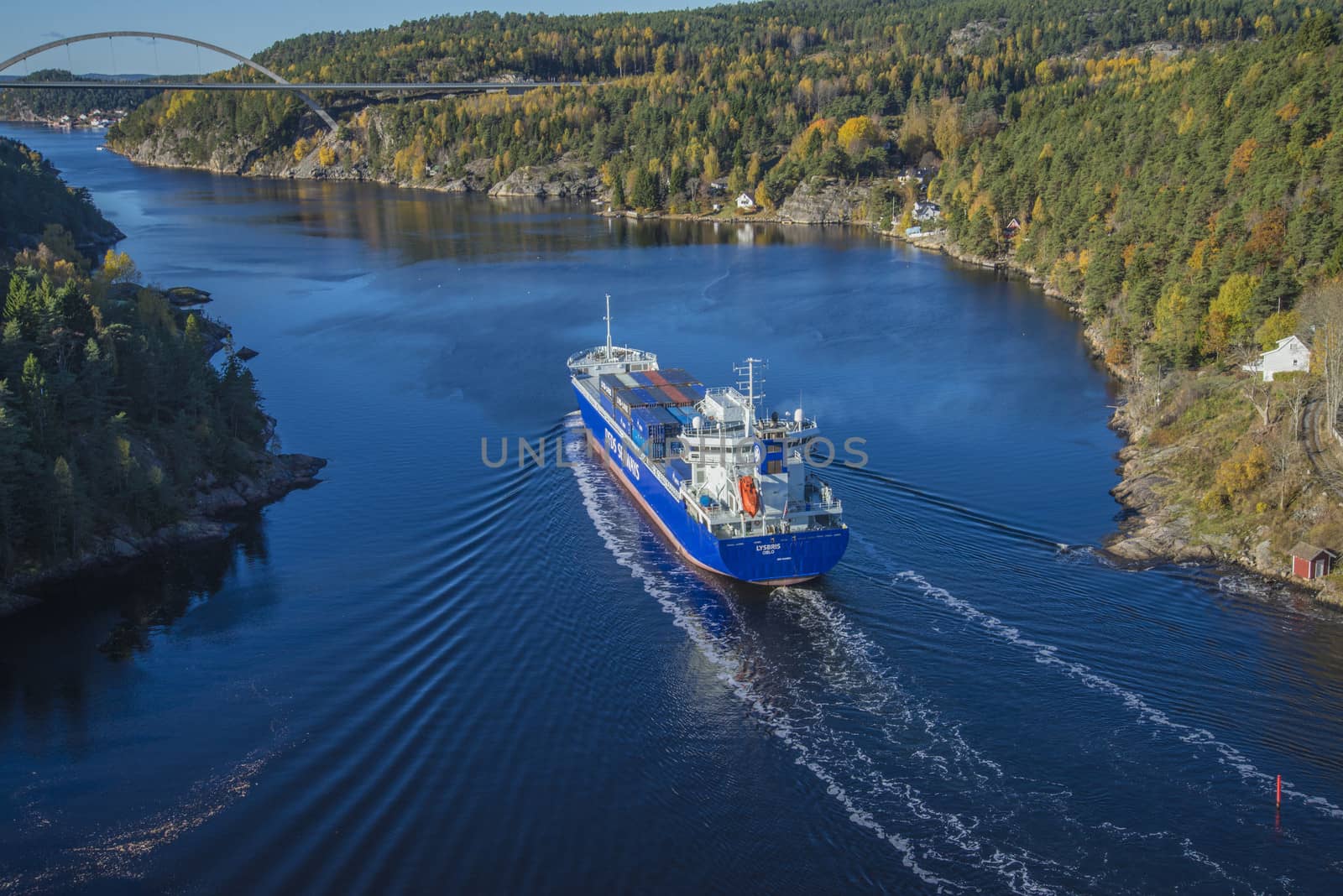 MV Lysbris sailing through Ringdalsfjord from Halden, Norway harbor and out to the open ocean. Vessel's Details: Ship Type: Cargo / container ship, built 1999, Length x Breadth: 129 m X 18 m, Gross Tonnage: 7409, DWT (deadweight tons): 7500 h, Flag: Norway (NO). Photo is shot from Svinesund bridge 18 October 2013.