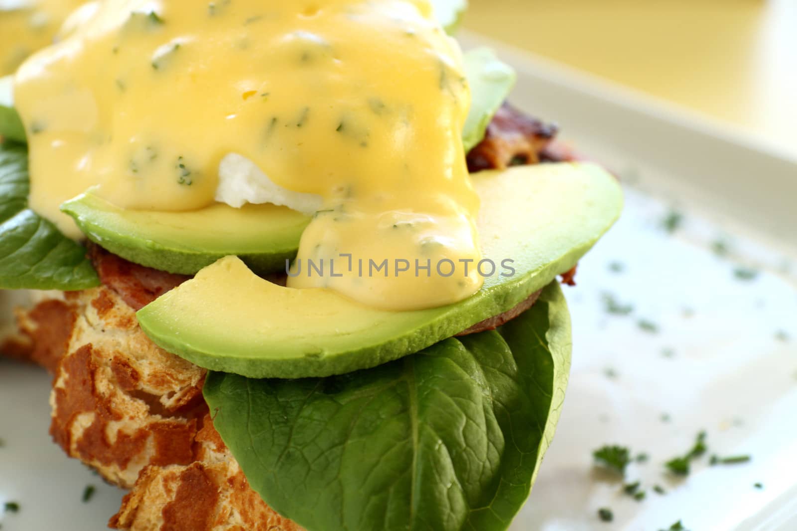 Delicious eggs benedict with hollandaise sauce with avocado.