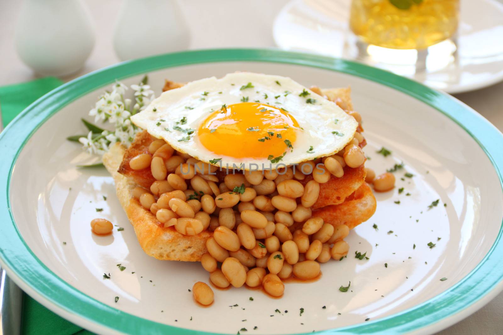 Delicious old fashioned breakfast of a fried egg on a baked beans stack on toast.
