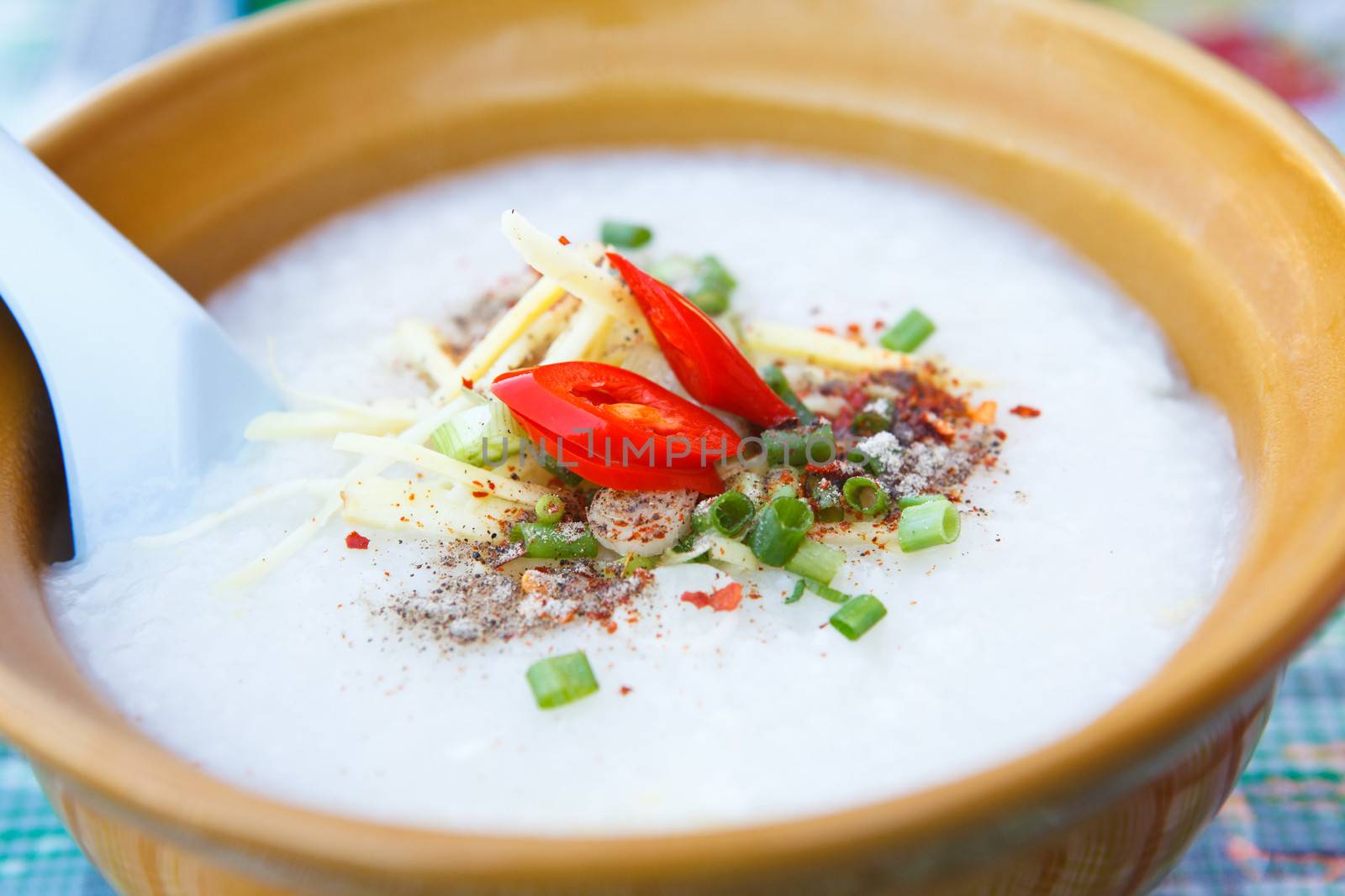 close up of rice porridge in ceramic bowl by khunaspix