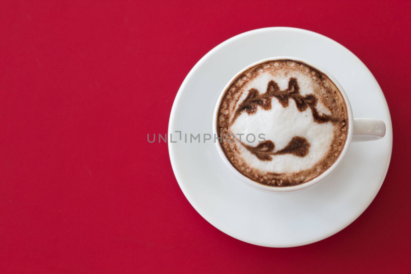 Coffee in a white cup on a red background.