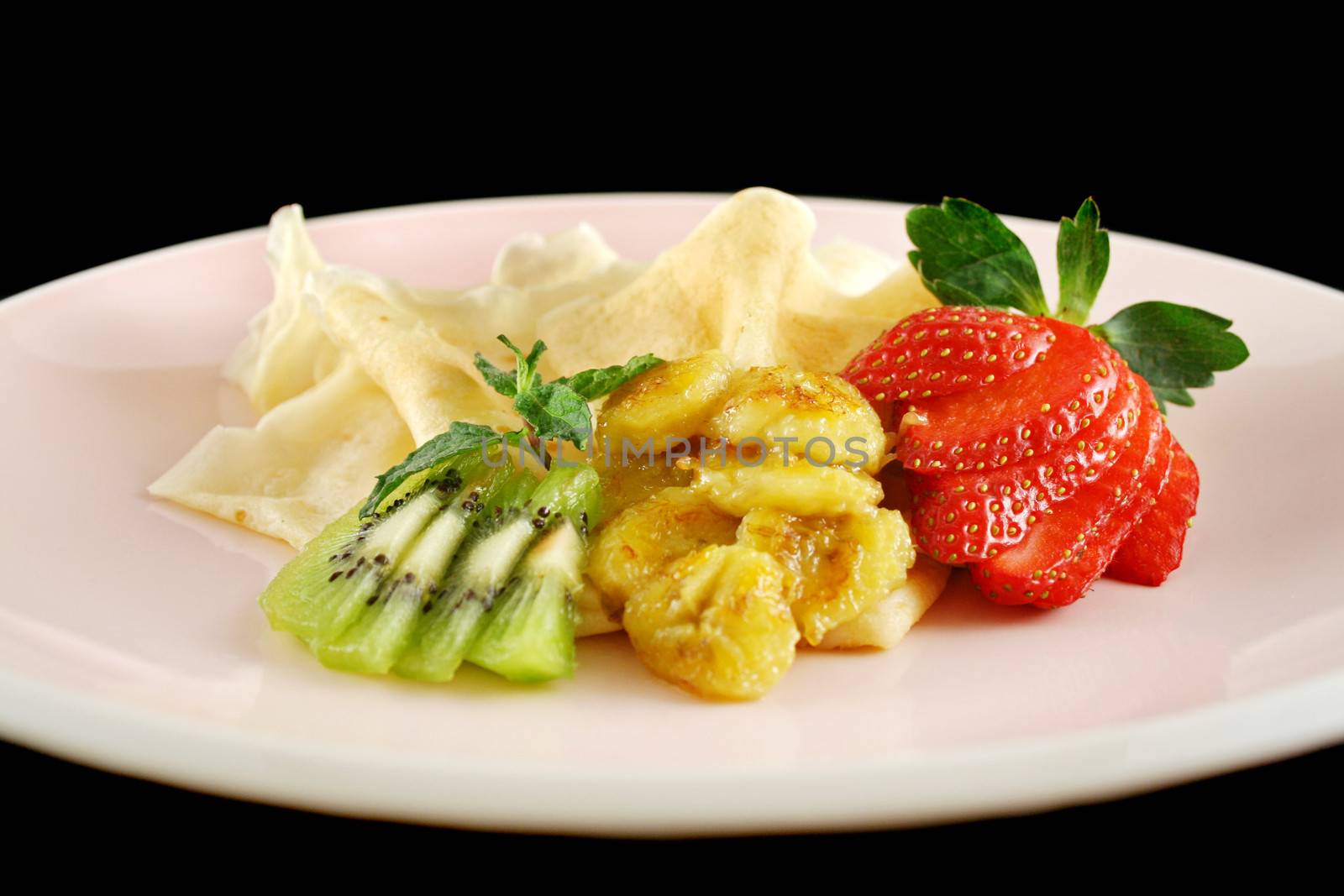 Caramelized banana crepes with strawberries and kiwi fruit.