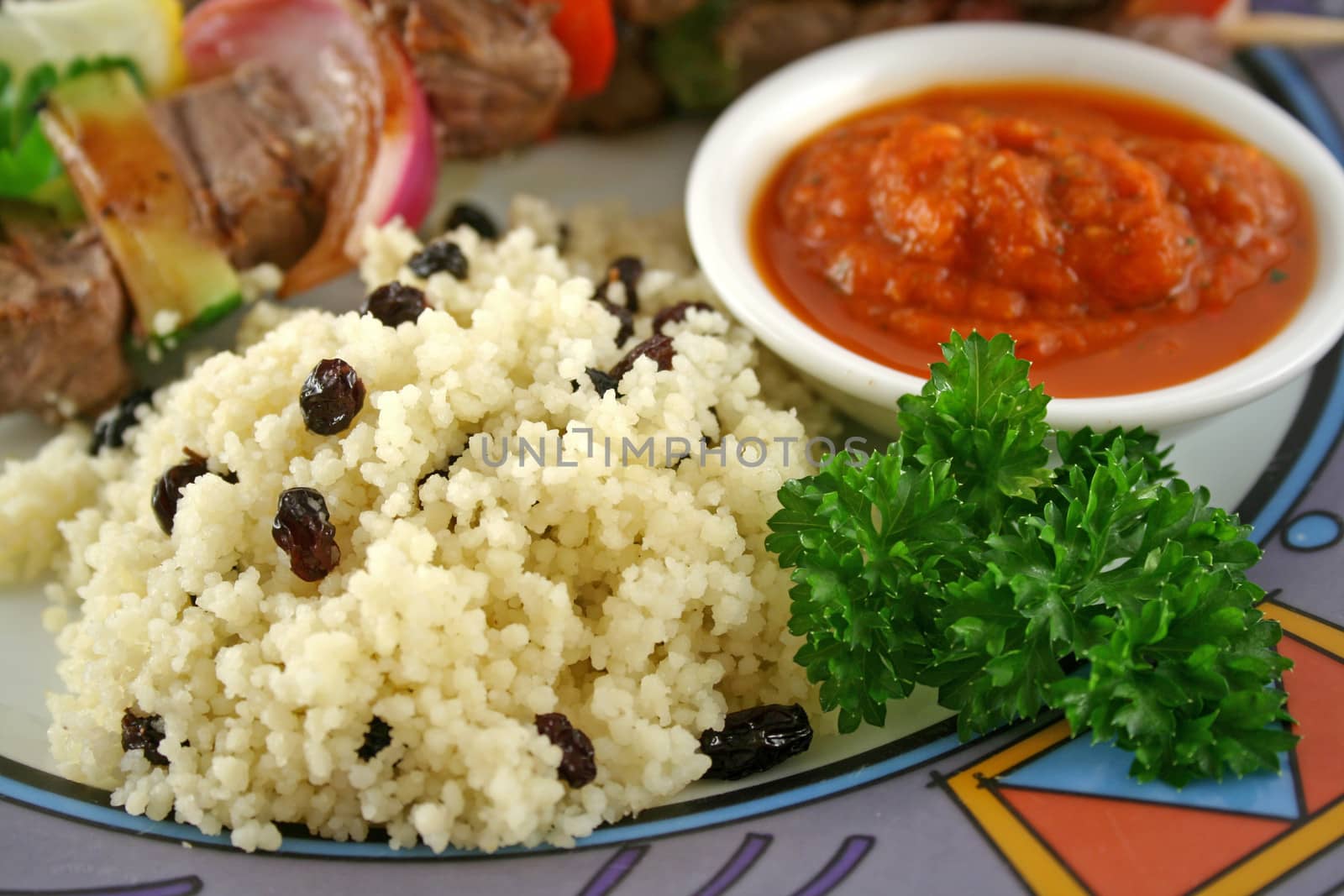 Beef kebabs and currant couscous with harissa sauce.