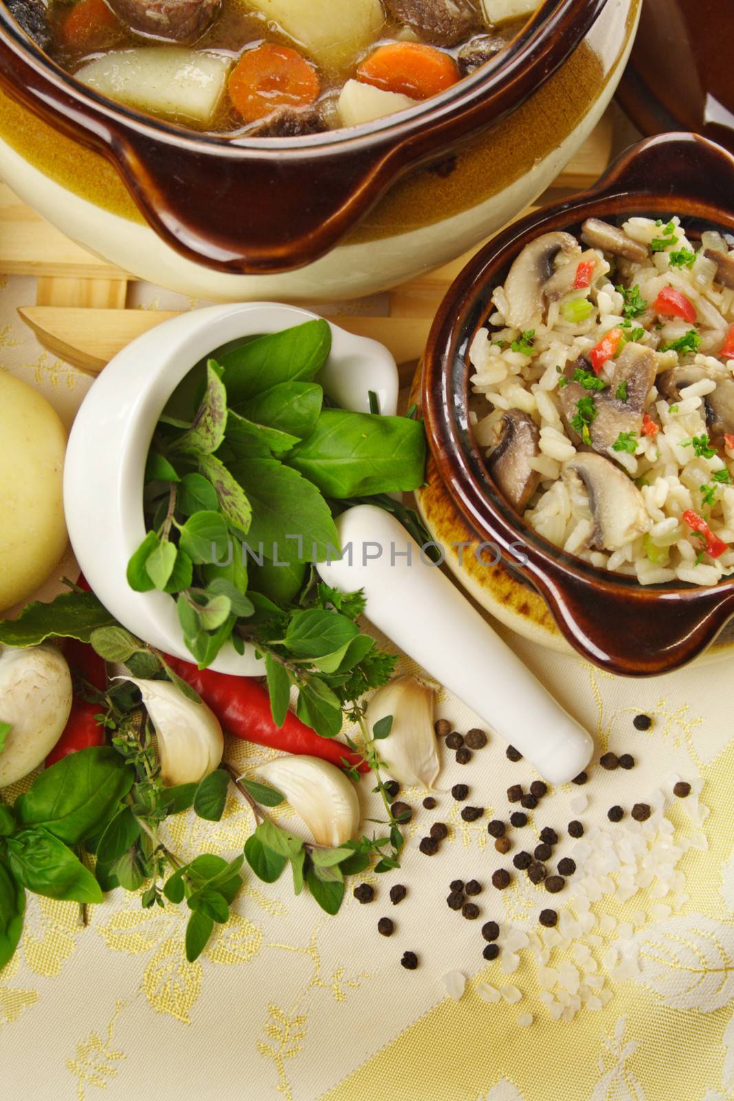 Table setting of freshly baked beef stew with savory rice and seasonal vegetables and herbs.