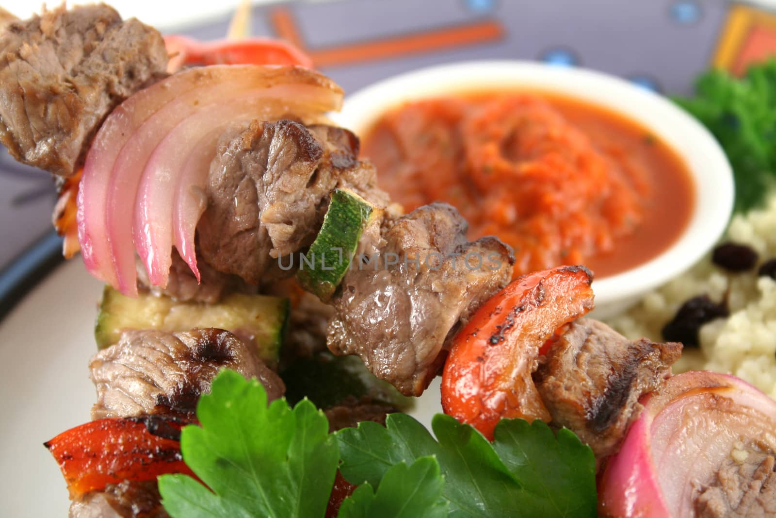 Beef kebabs and currant couscous with harissa sauce.