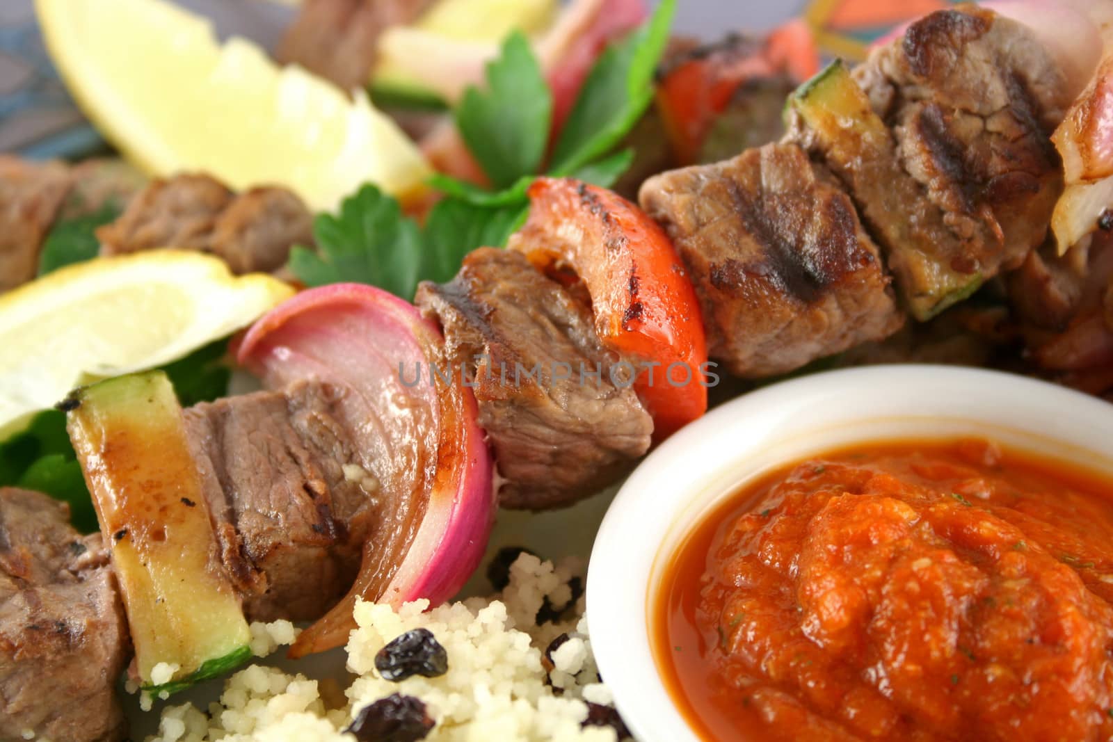 Beef kebabs and currant couscous with harissa sauce.