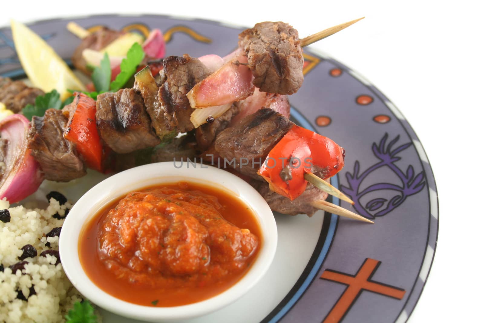 Beef kebabs and currant couscous with harissa sauce.