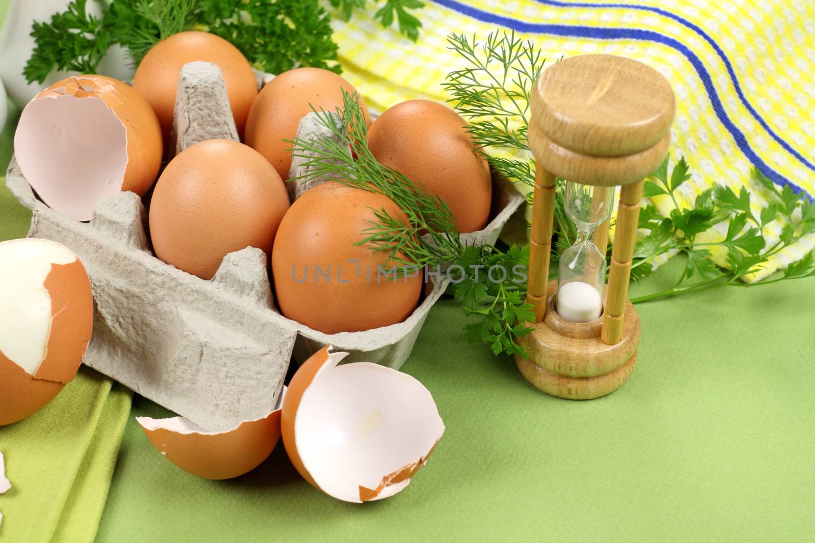 Egg timer with carton of boiled and cracked eggs with parsley.