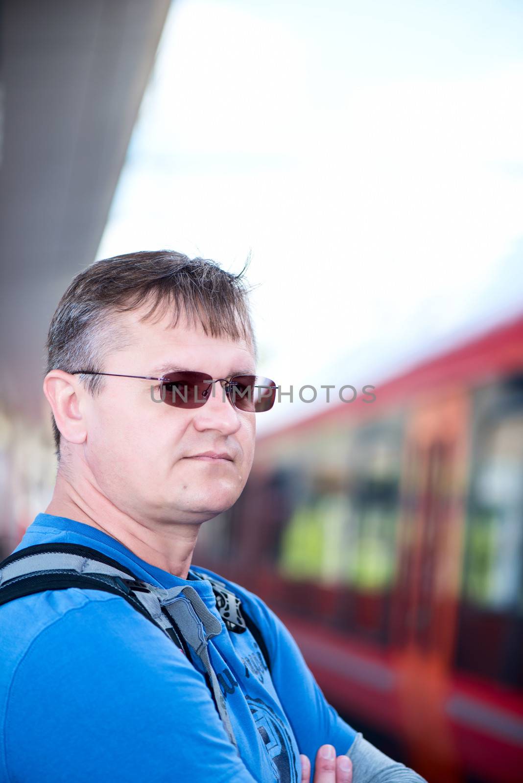 Mature men in glasses with backpack  on train station