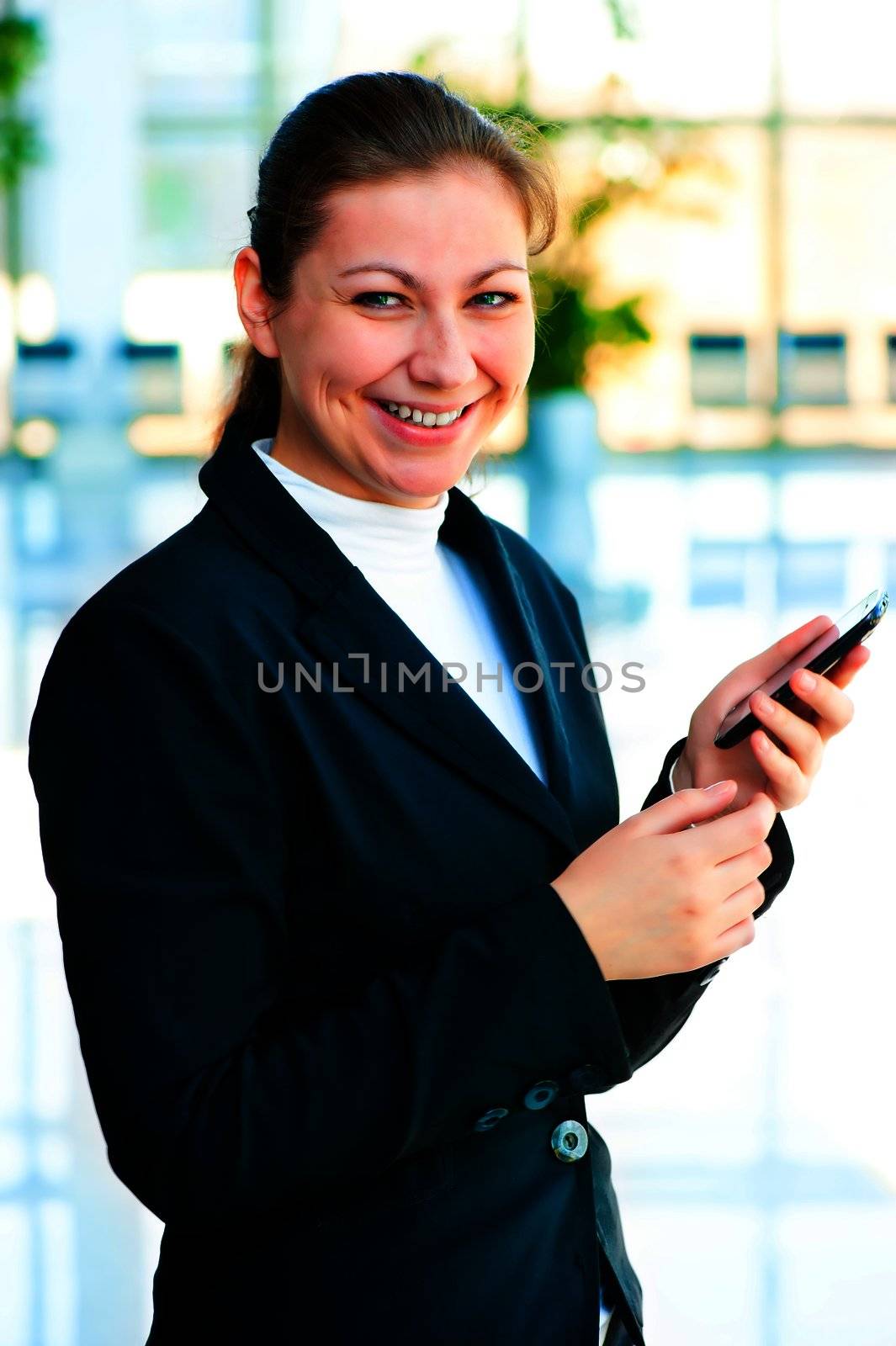 Young happy business woman with a mobile phone in hand