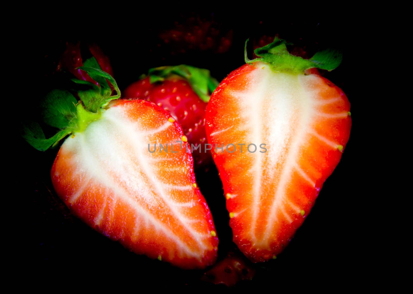 cut strawberry on a black background