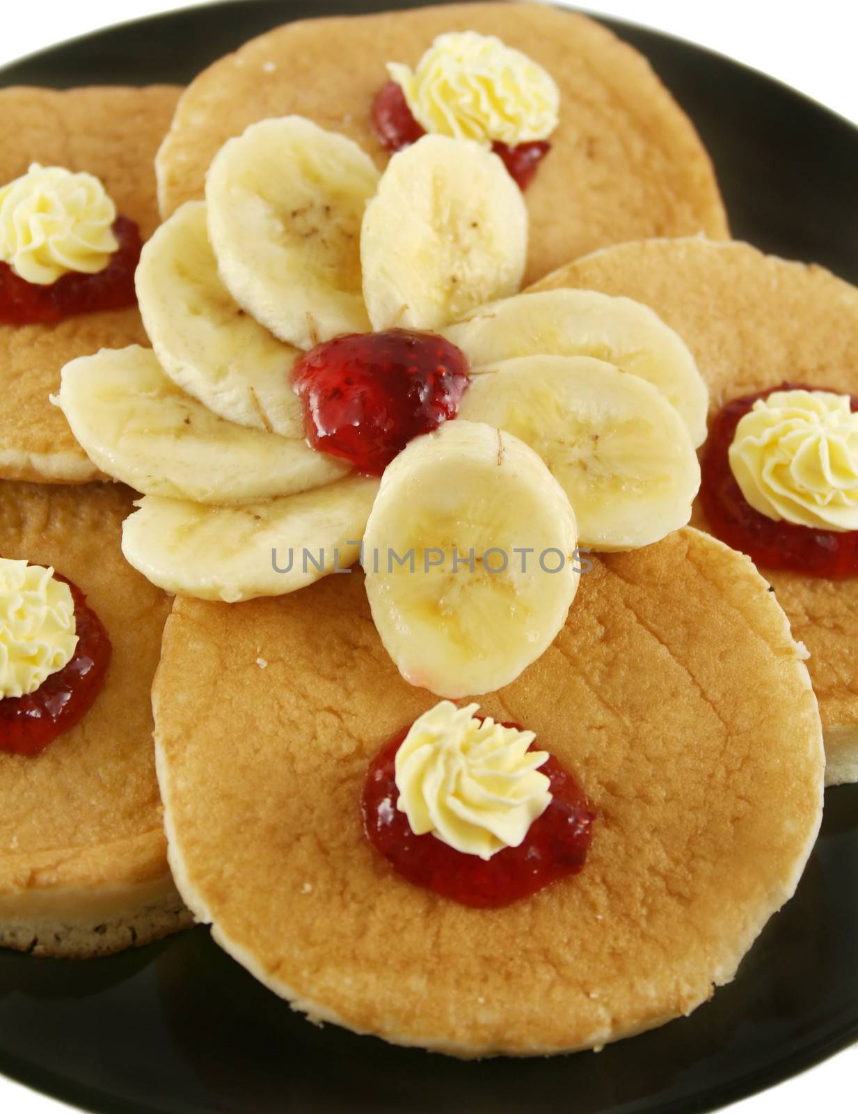 Strawberry jam and butter pancakes with sliced banana.