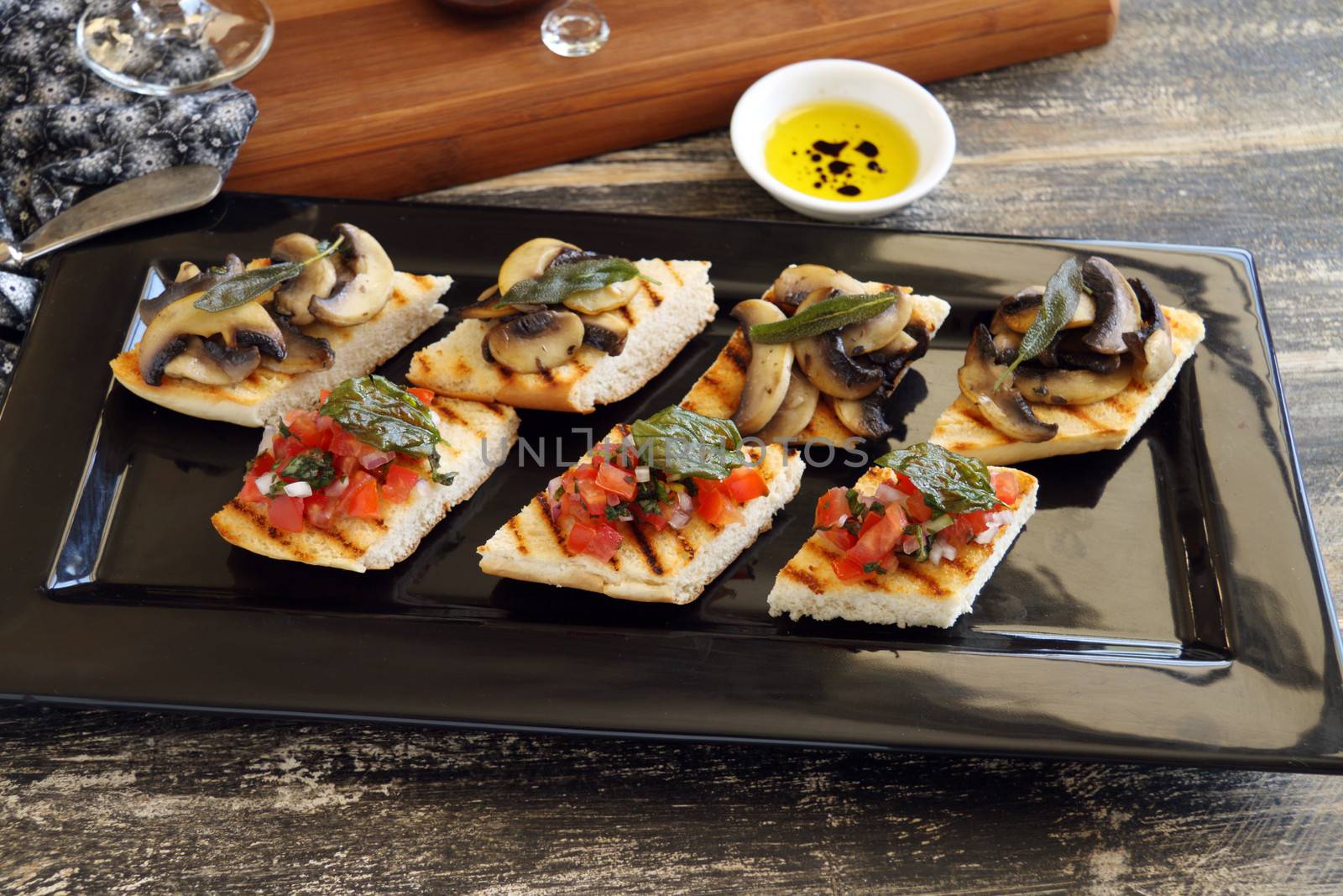 A selection of finger food with mushrooms, tomato and onion including brushette and dips.