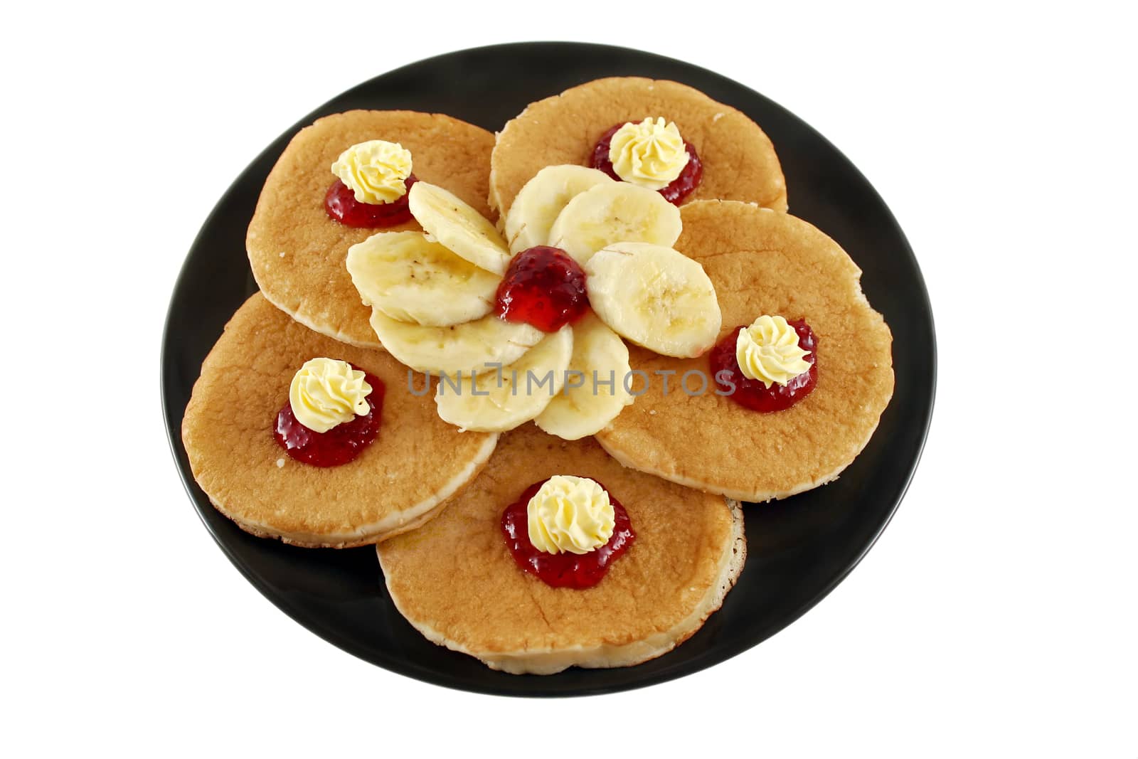 Delicious pancakes with butter swirls and strawberry jam with banana.