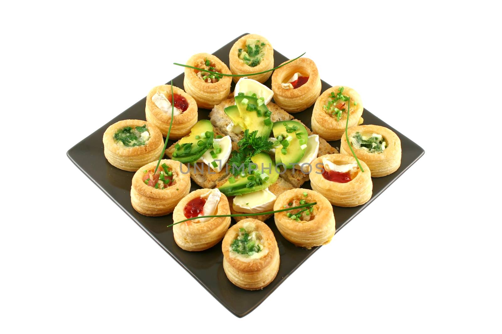 Assorted vol au vonts and avocado and camembert bites on a platter.