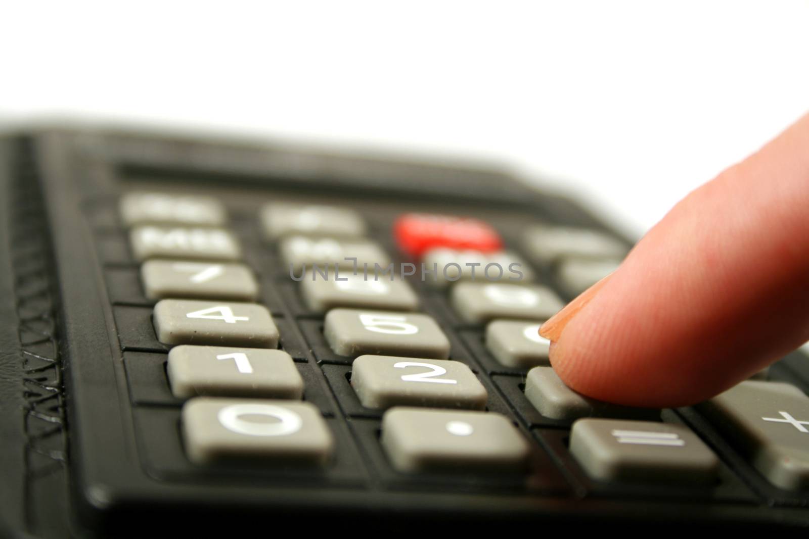 Close up of fingertip on the the keyboard of a calculator.