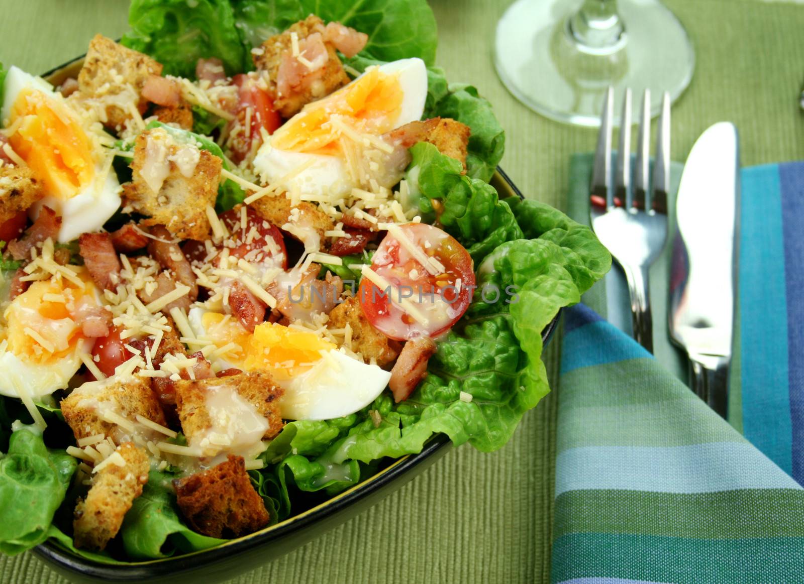 Fresh Caesar salad with lettuce, cherry tomatoes, parmesan cheese, egg, bacon and croutons.