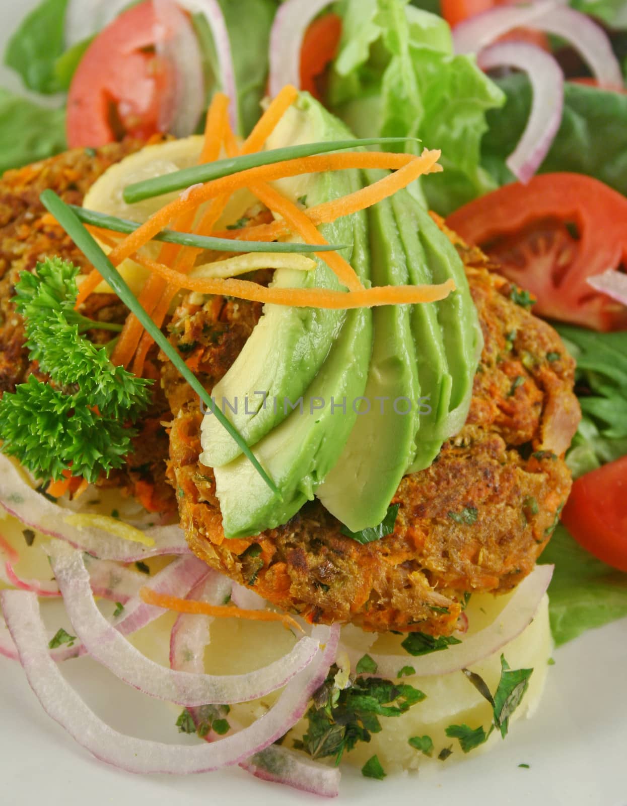 Carrot And tuna patties on a herbed potato stack with salad.