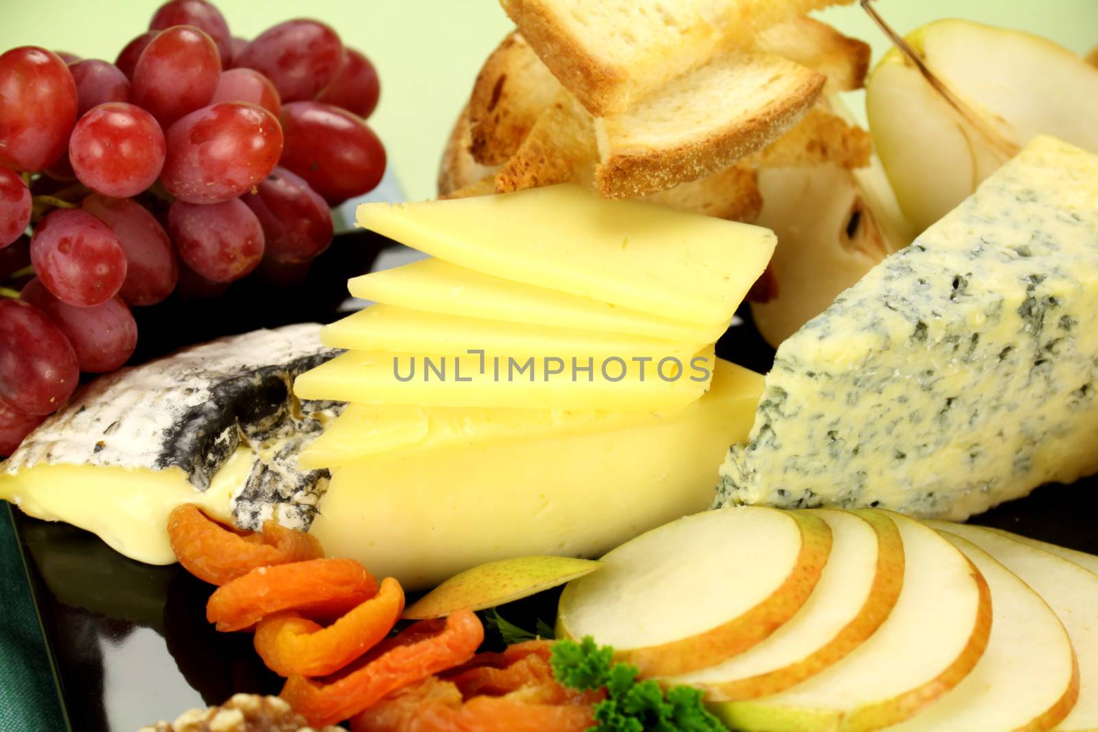 Delicious cheese platter with various cheeses and fruits ready to serve.