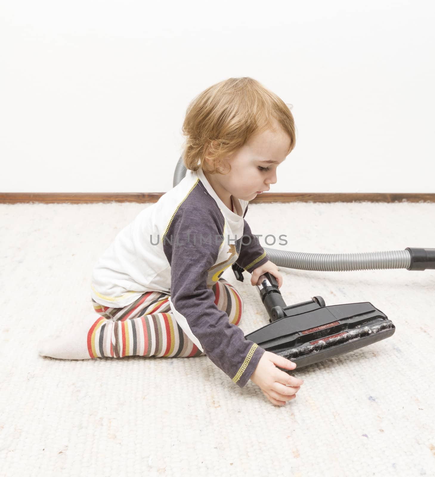 young child cleaning vacuum cleaner by gewoldi