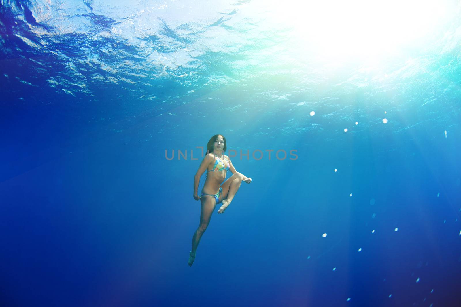 athletic girl diving under the sea