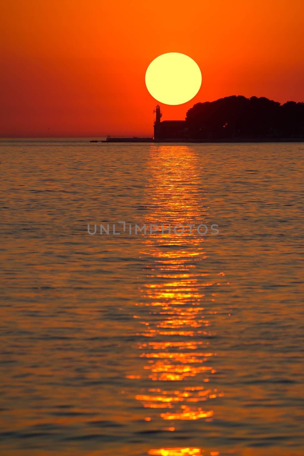 Sunset over lighthouse in Zadar vertical view, Dalmatia, Croatia