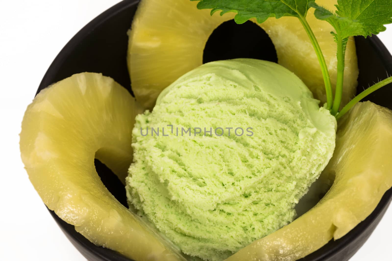 pistachio ice cream with pineapple rings and mint leaf