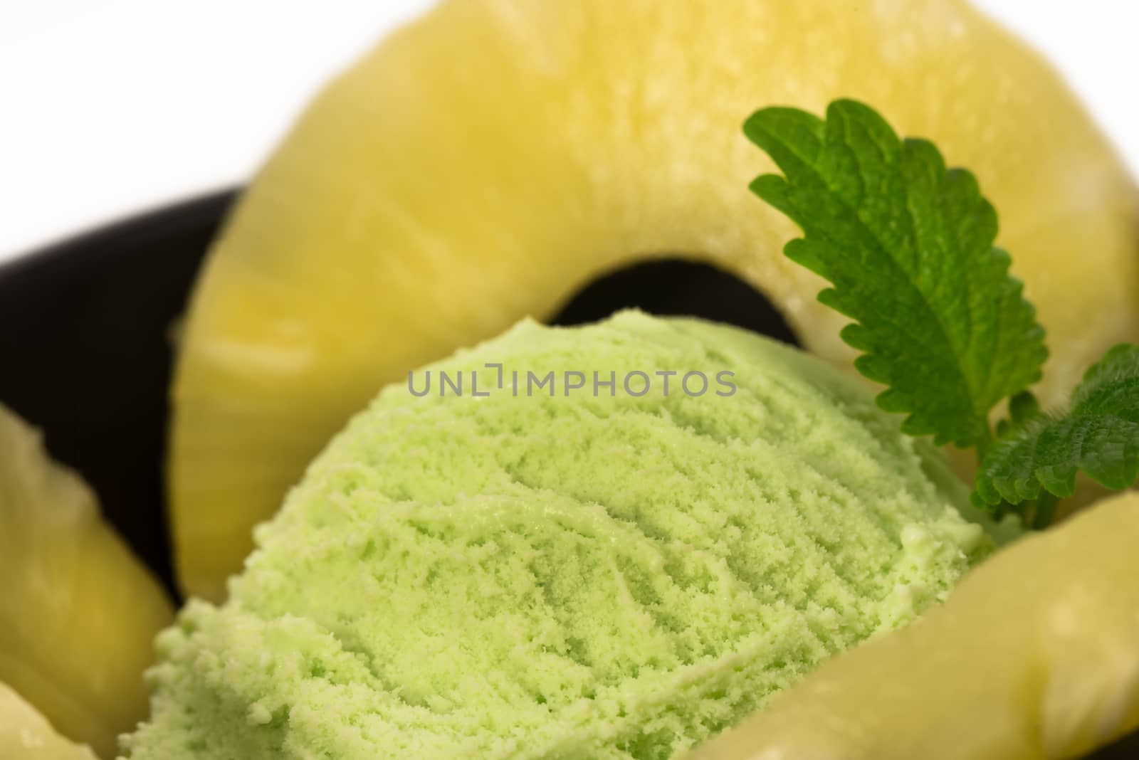 pistachio ice cream with pineapple rings and mint leaf