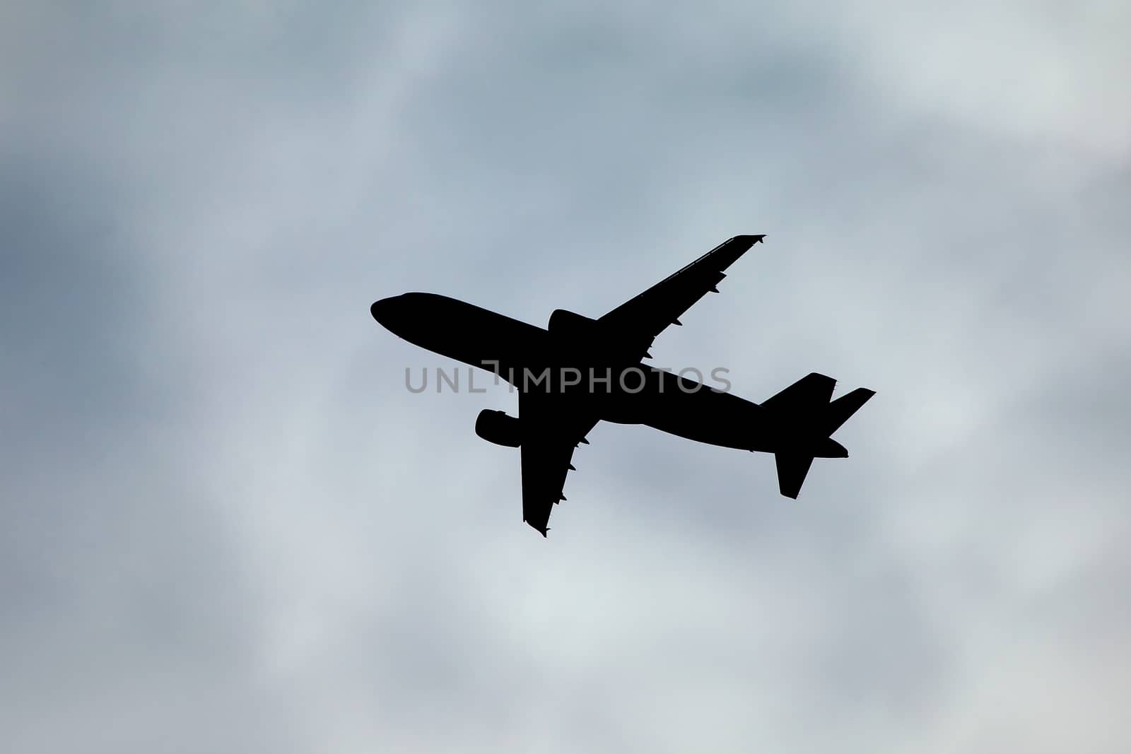 Plane silhouette against cloudy sky