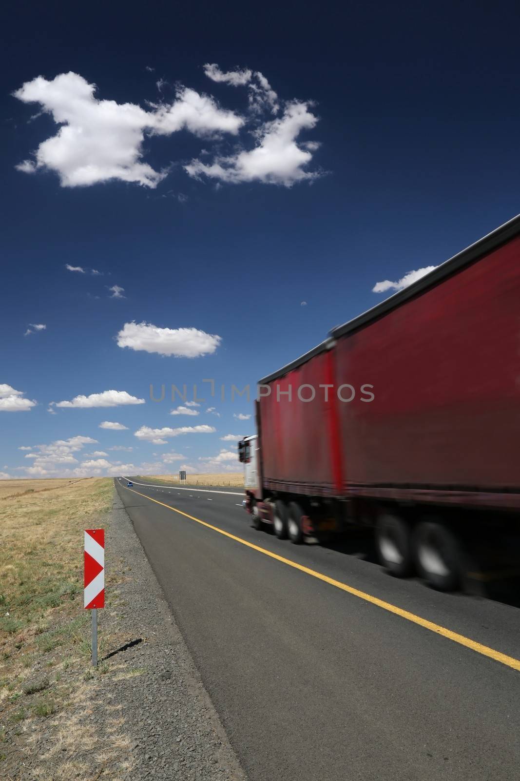 Big transporter truck travelling along the highway at speed