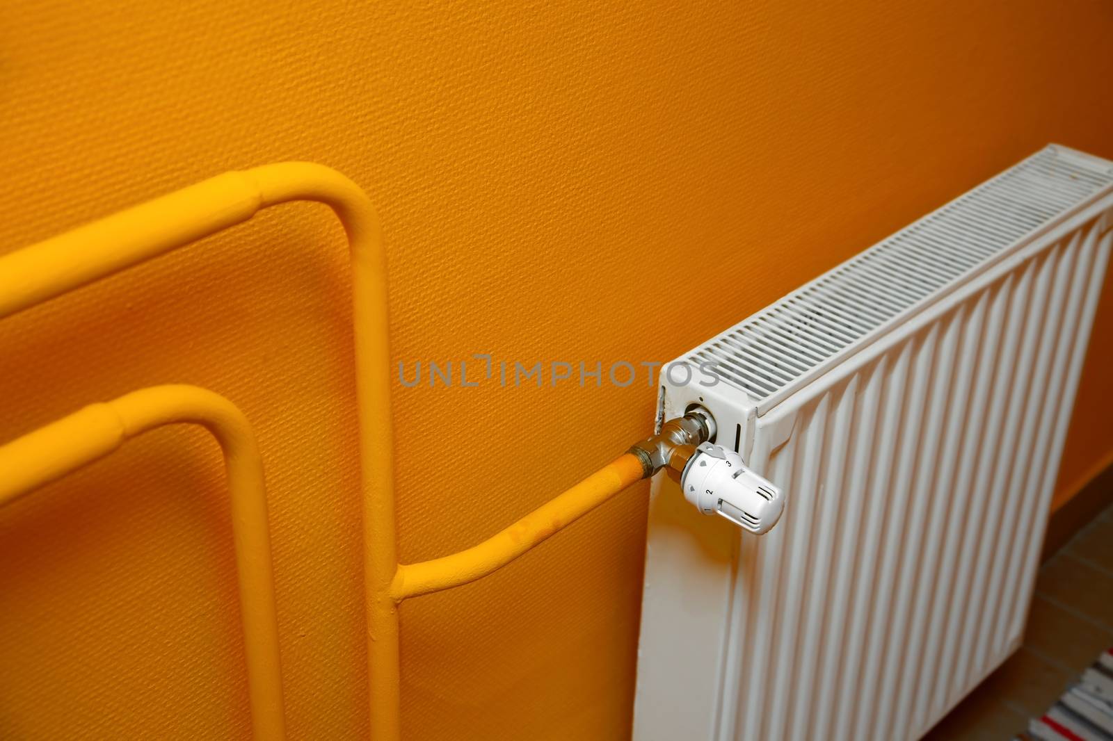 Heating radiator detail against orange wall