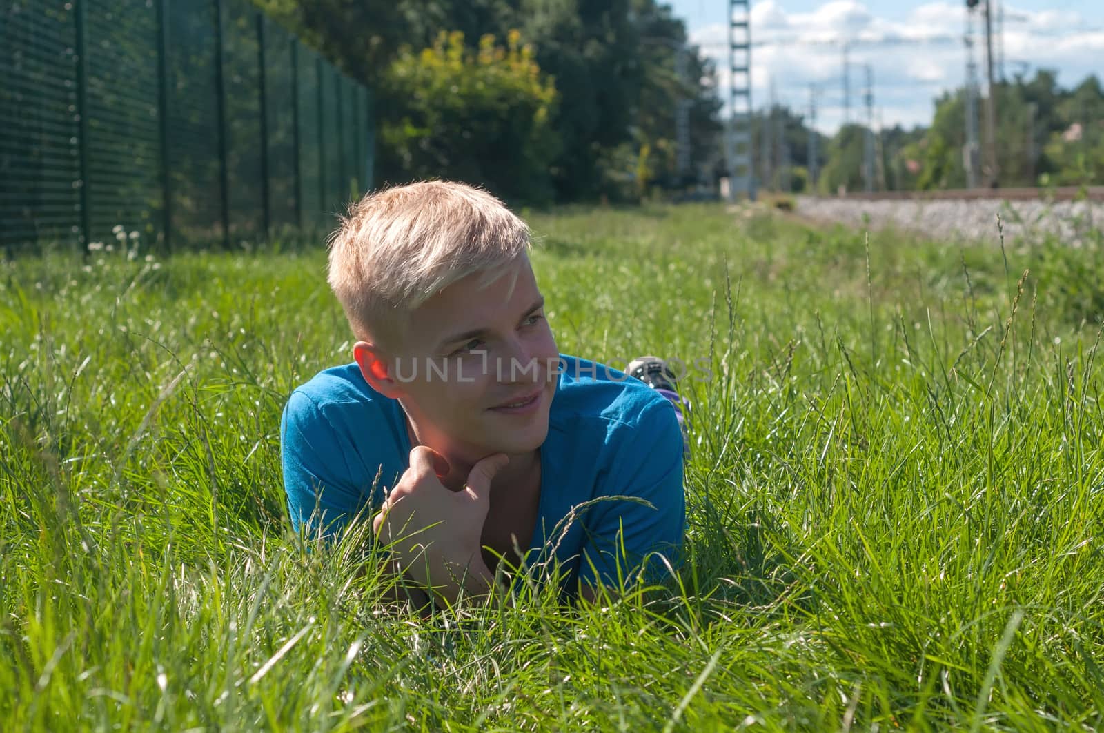 Man in blue t-shirt lying in a grass