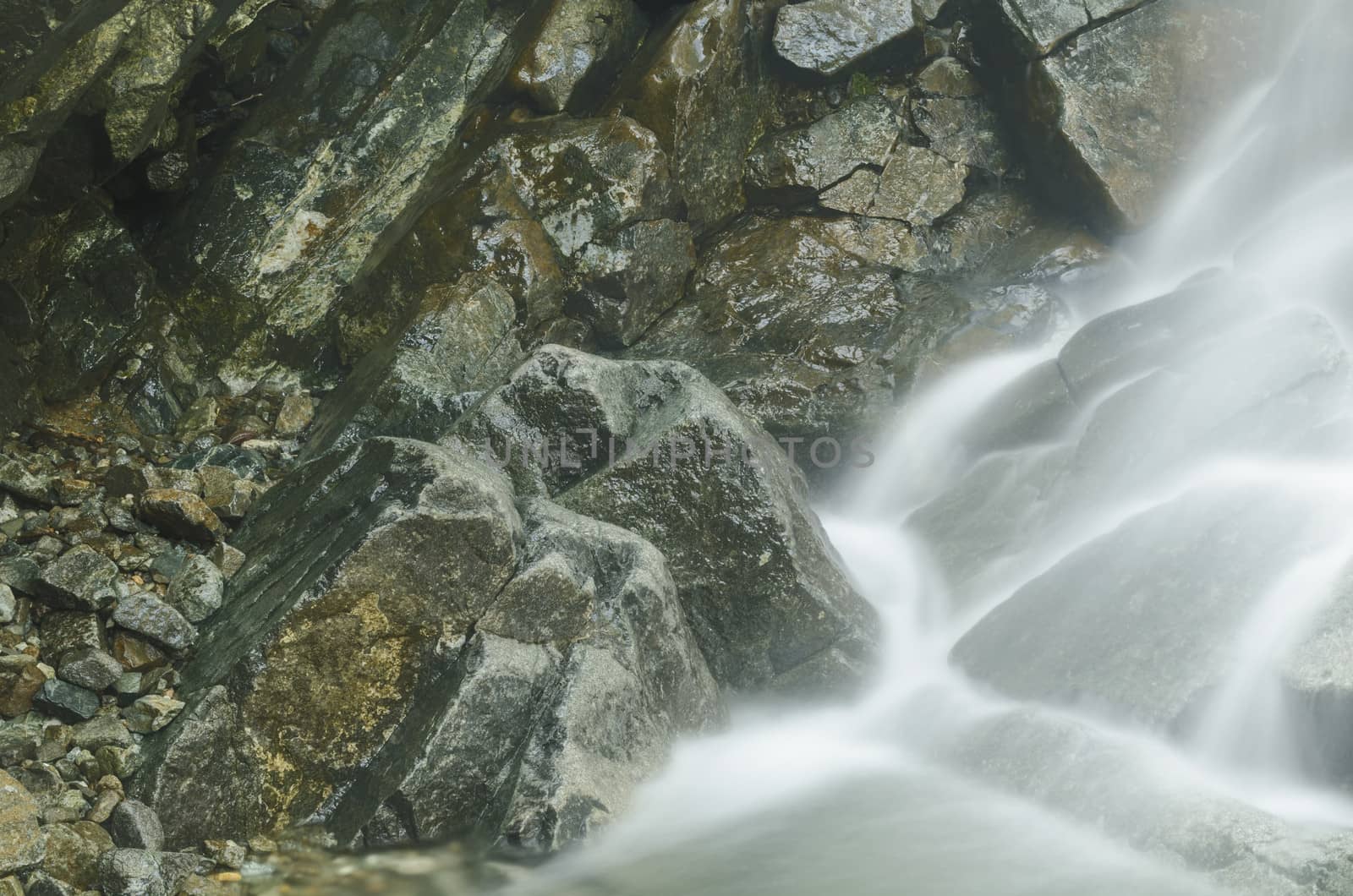 Small natural waterfall in a mountain resort shot from above